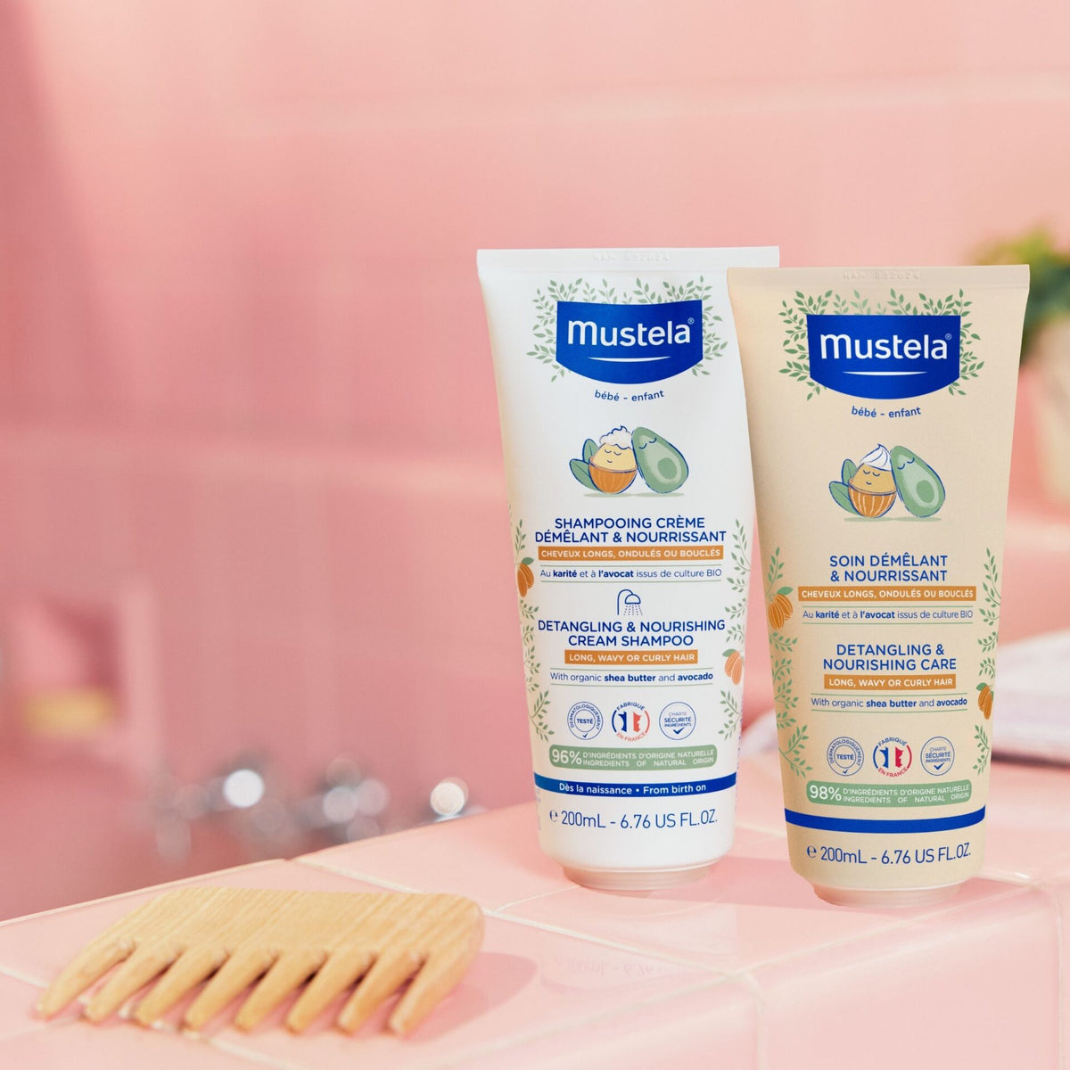 Mustela baby care products on a pink surface with a blurred background