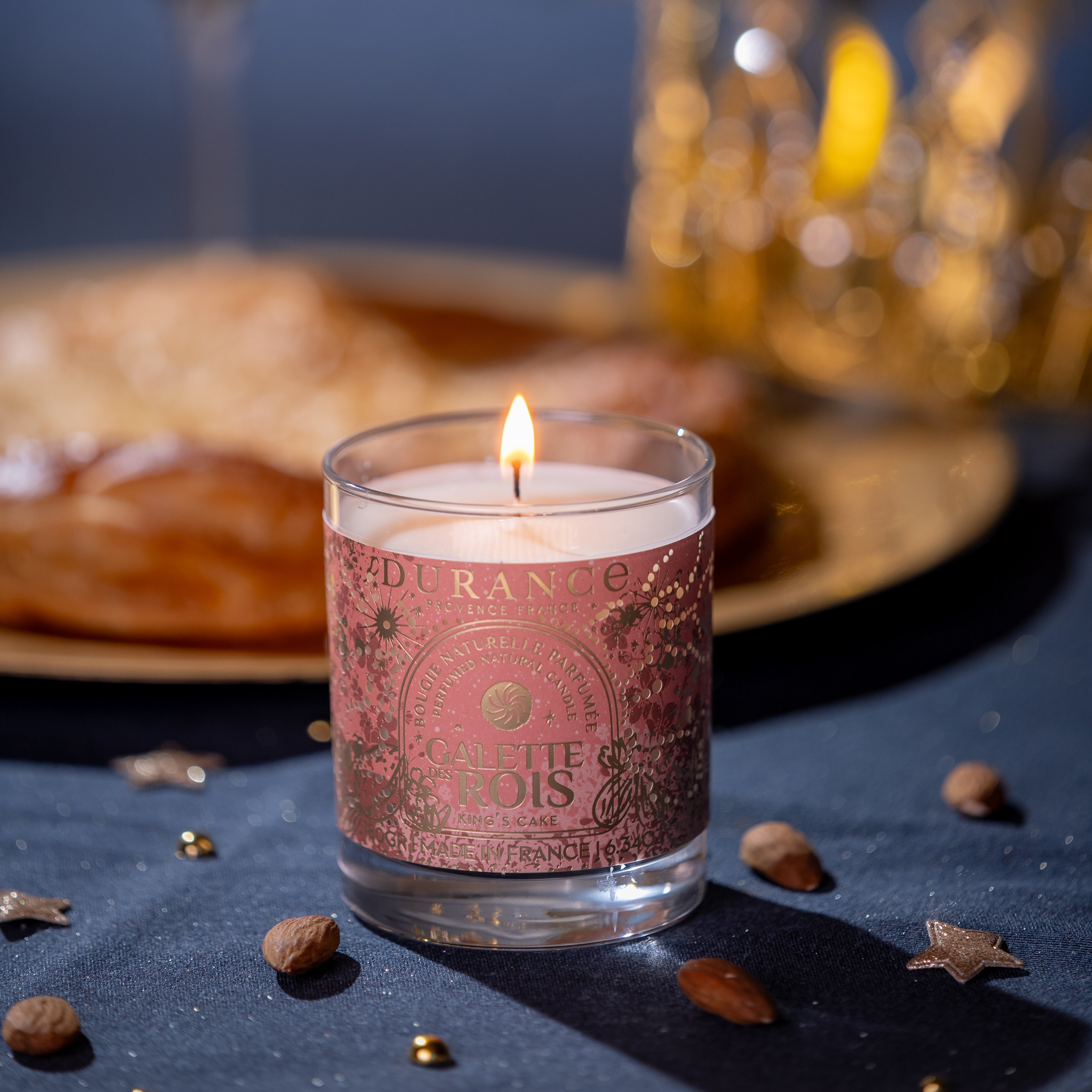 Candle with decorative label on a dark surface with a blurred background