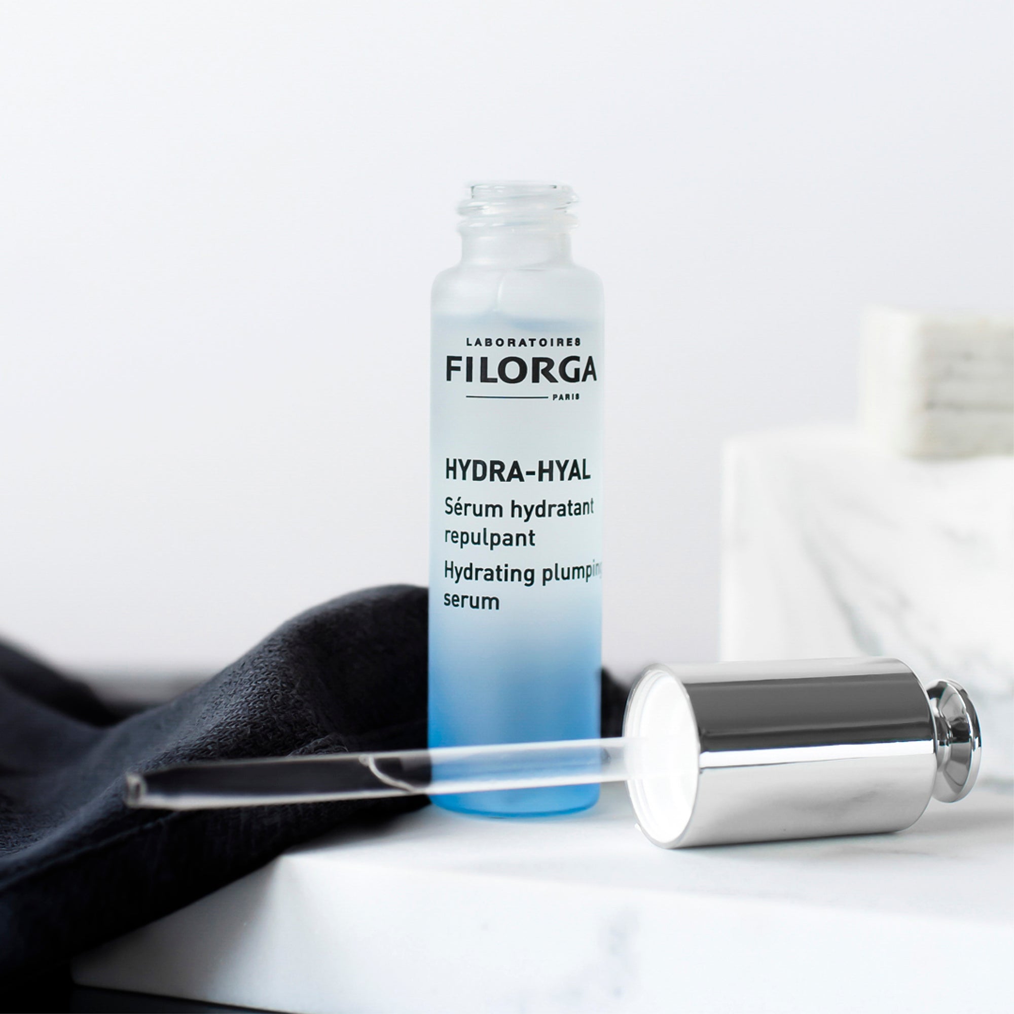 Filorga Hydra-Hyal serum bottle with applicator on a white background