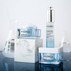 Filorga skincare products including a serum, cream, and packaging on a reflective surface.