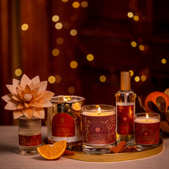 Decorative candles and bottles on a tray with a warm, blurred background
