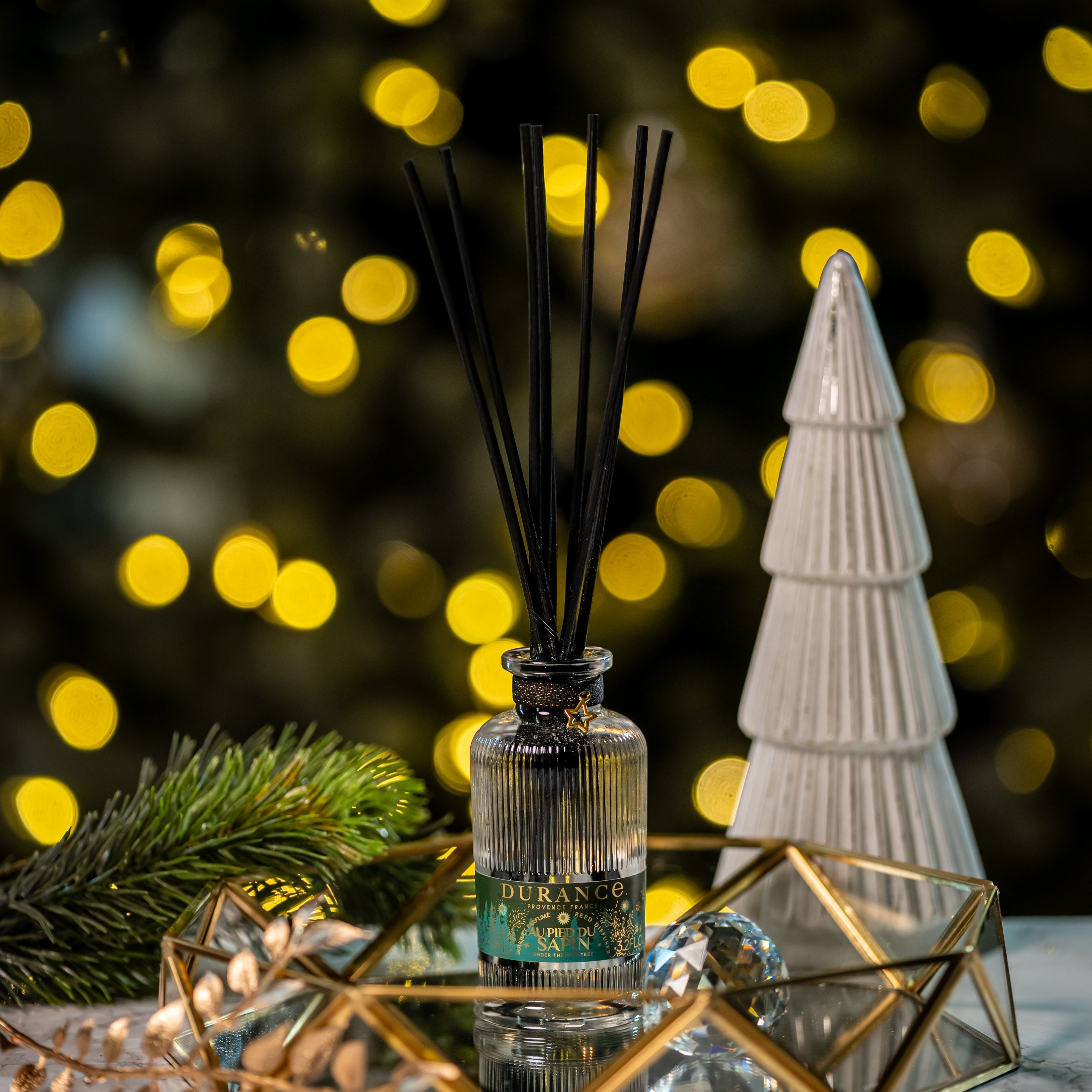 Decorative diffuser with a Christmas tree and lights in the background