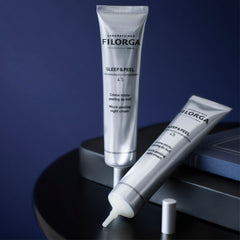 Two tubes of Filorga Sleep & Peel cream on a dark surface with a blue background