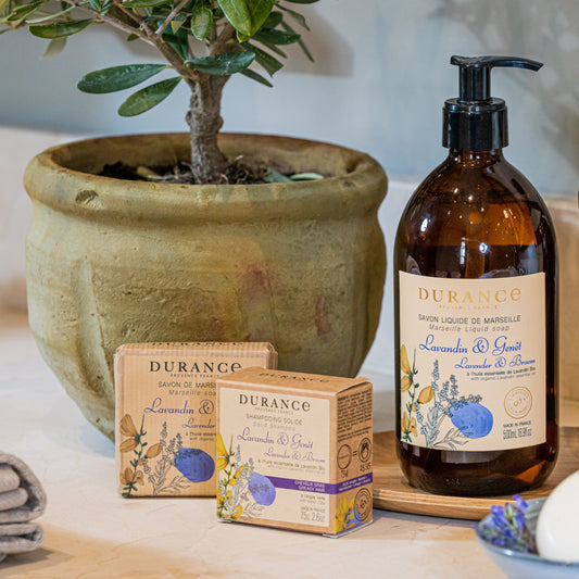 Durance soap and bottle on a wooden surface with a potted plant in the background