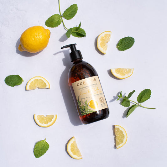 Brown bottle with pump and lemon slices on a light gray background