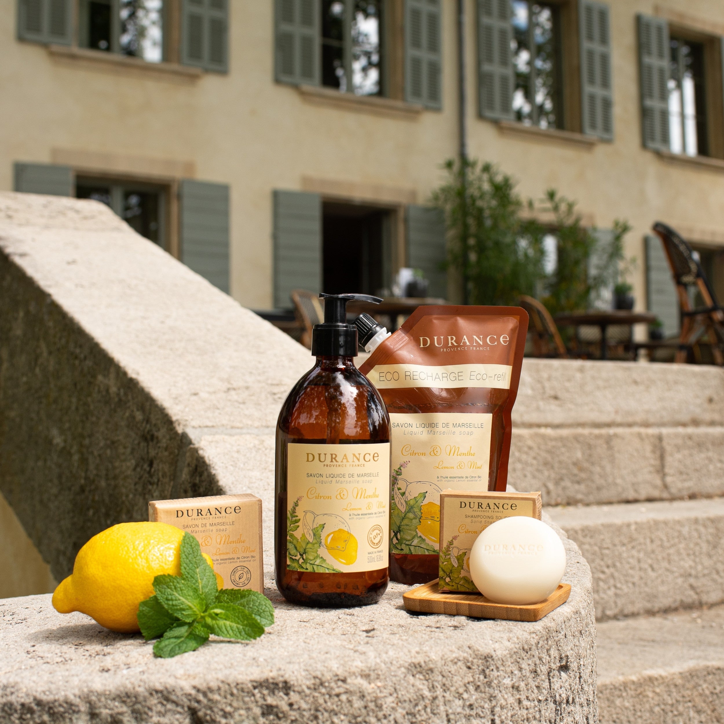 Durance skincare products on stone steps with a lemon and mint leaf.