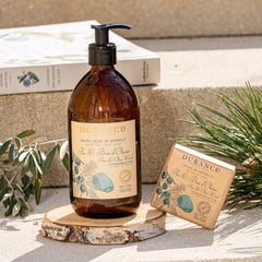 Brown bottle with pump and soap bar on a wooden stand outdoors