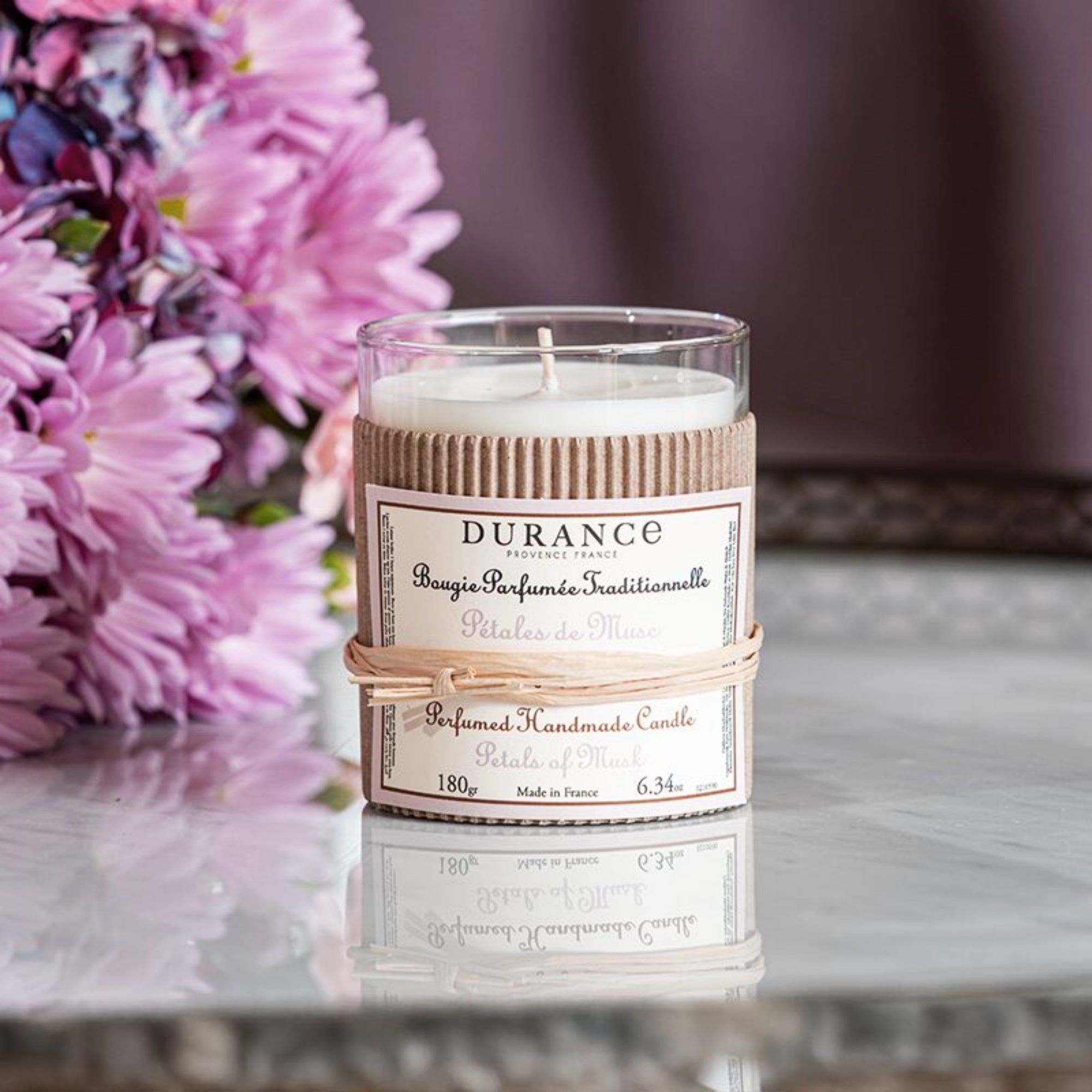 Durance candle with floral arrangement in the background